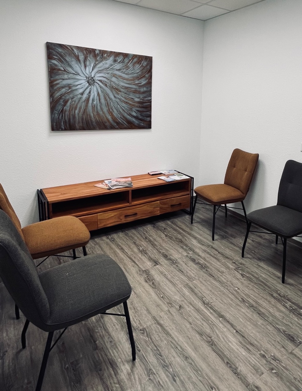 Wartebereich der psychotherapeutischen Praxis mit Sitzgelegenheiten und einem Bild an der Wand